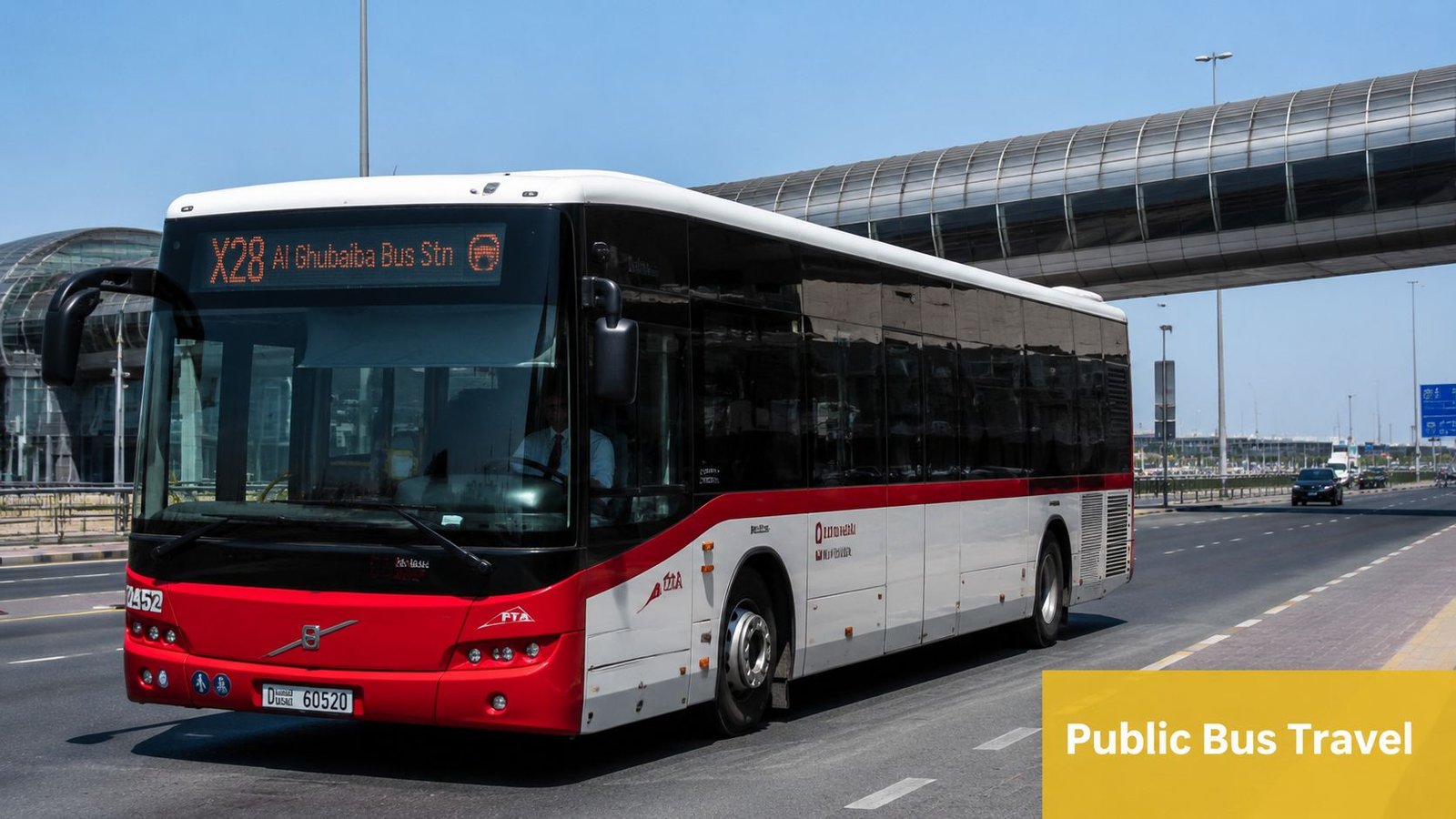 A red and white public bus traveling on a road with an overhead walkway in Dubai.