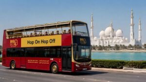 Abu Dhabi hop on hop off sightseeing bus passing Sheikh Zayed Grand Mosque with tourists enjoying a city tour in Abu Dhabi