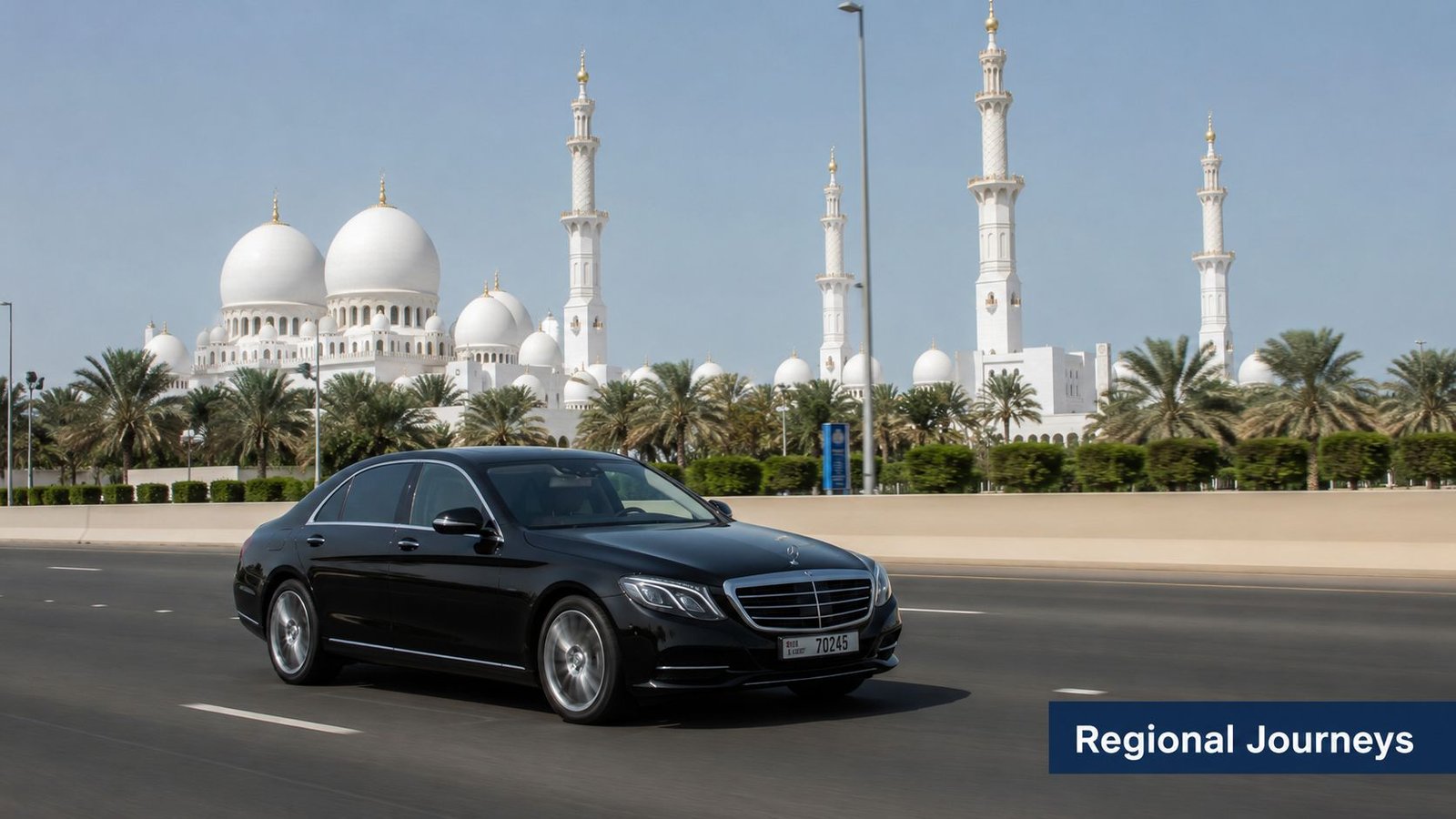 A black Mercedes-Benz sedan driving on a highway with the Sheikh Zayed Grand Mosque in the background.